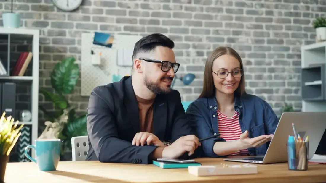 Couple managing wedding details on laptop
